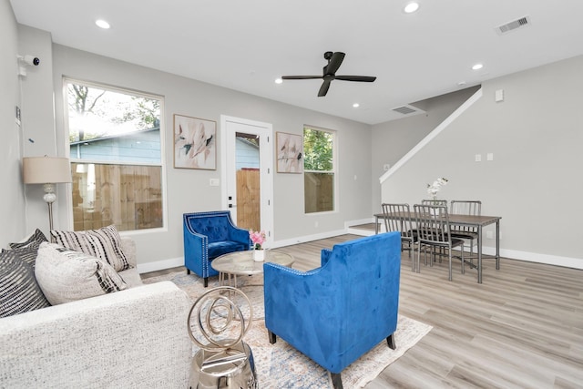 living room featuring light wood-type flooring and ceiling fan