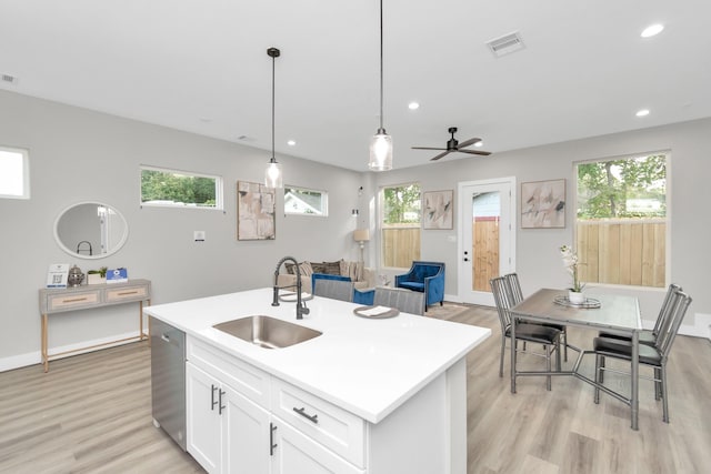 kitchen featuring sink, decorative light fixtures, white cabinets, ceiling fan, and a kitchen island with sink