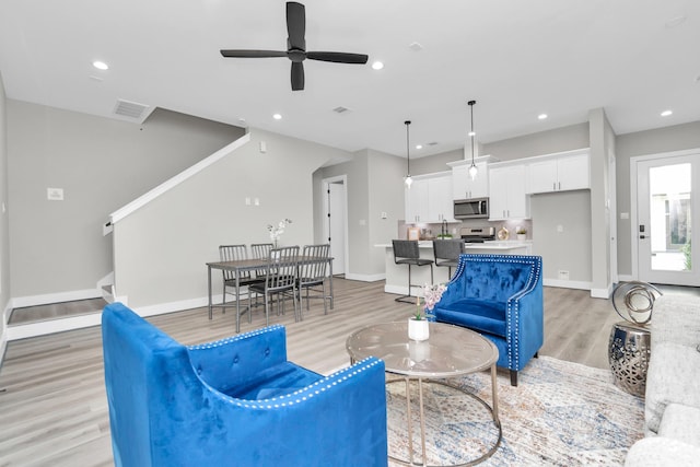 living room with ceiling fan and light hardwood / wood-style floors