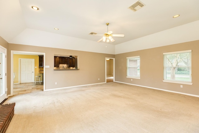 unfurnished living room featuring light carpet, baseboards, visible vents, lofted ceiling, and ceiling fan