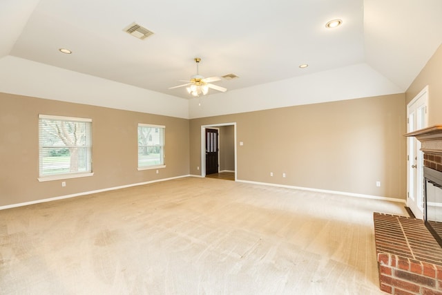 unfurnished living room featuring ceiling fan, vaulted ceiling, light carpet, and a fireplace