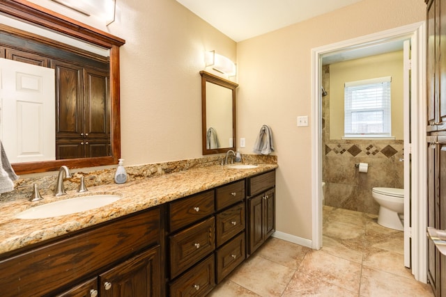 bathroom with tile patterned floors, a sink, double vanity, and toilet