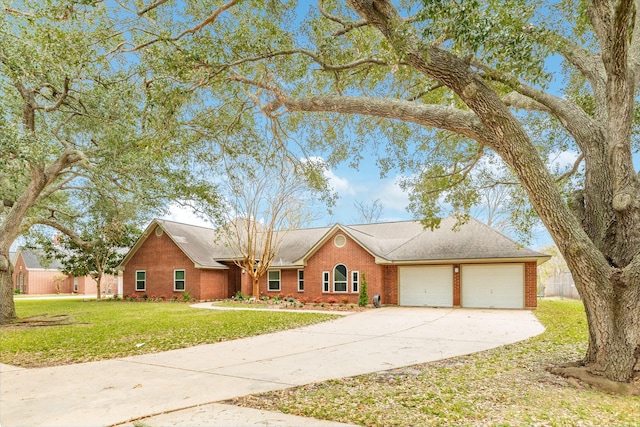 view of front facade featuring an attached garage, a front lawn, driveway, and brick siding
