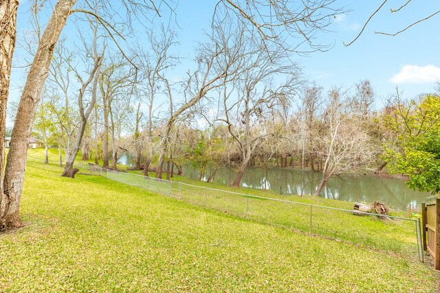 view of yard with fence and a water view