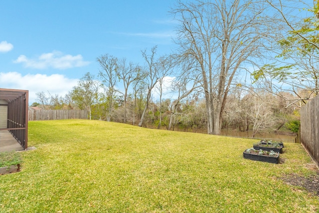 view of yard with a fenced backyard and a vegetable garden