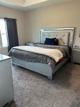 carpeted bedroom featuring a tray ceiling