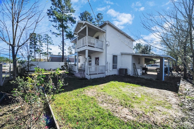 exterior space with a balcony, central AC, a yard, and a carport