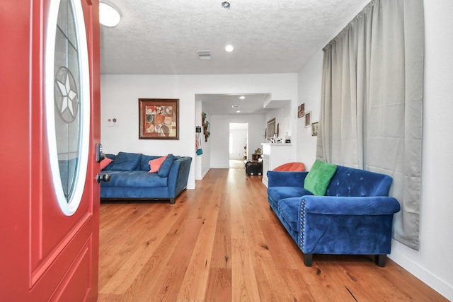 interior space with a textured ceiling and light hardwood / wood-style floors