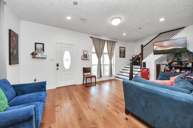 living room with wood-type flooring and a textured ceiling