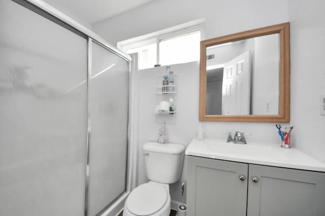 bathroom with toilet, an enclosed shower, and vanity