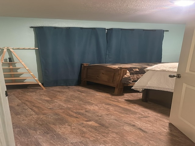 bedroom featuring a textured ceiling and wood-type flooring