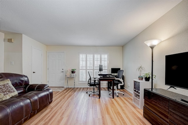 office area with a textured ceiling and light wood-type flooring