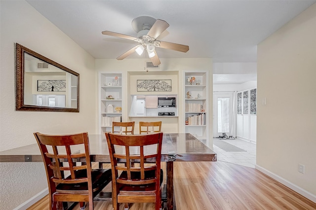 dining room featuring ceiling fan, built in features, and light hardwood / wood-style flooring