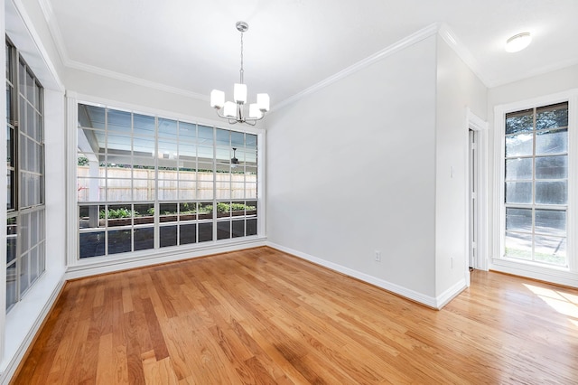 unfurnished dining area with ornamental molding, hardwood / wood-style floors, and a chandelier