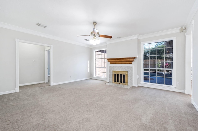 unfurnished living room featuring light carpet, a fireplace, ceiling fan, and crown molding