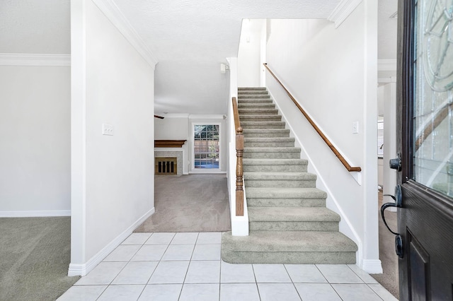 carpeted entryway with ornamental molding and a textured ceiling