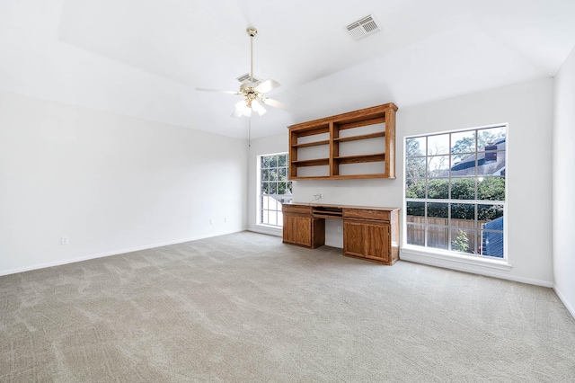 interior space with built in desk, light colored carpet, and ceiling fan