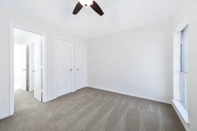 unfurnished bedroom with ceiling fan and light colored carpet