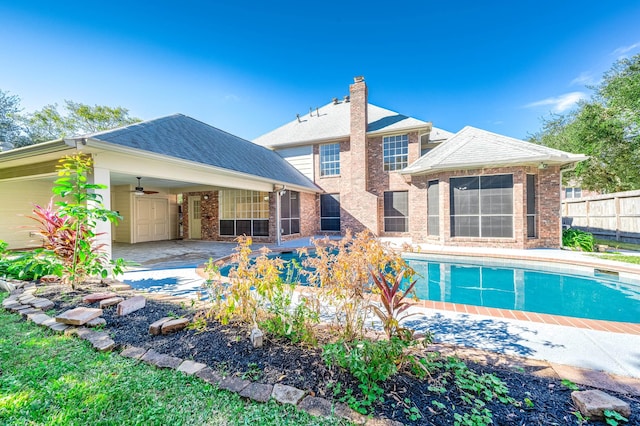 rear view of house with a patio area, ceiling fan, and a fenced in pool