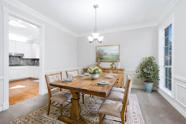 dining space with ornamental molding and a chandelier