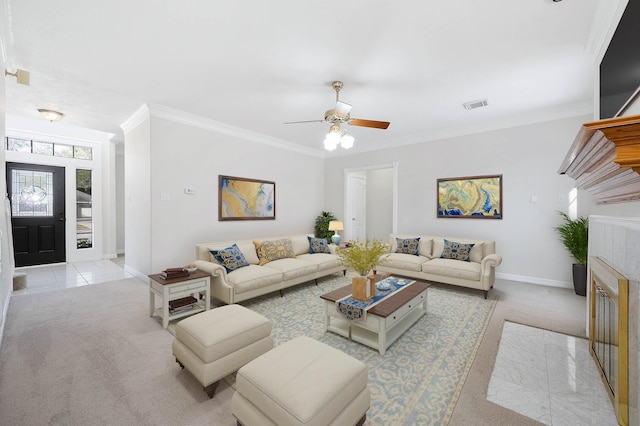 carpeted living room with a tile fireplace, ceiling fan, and ornamental molding