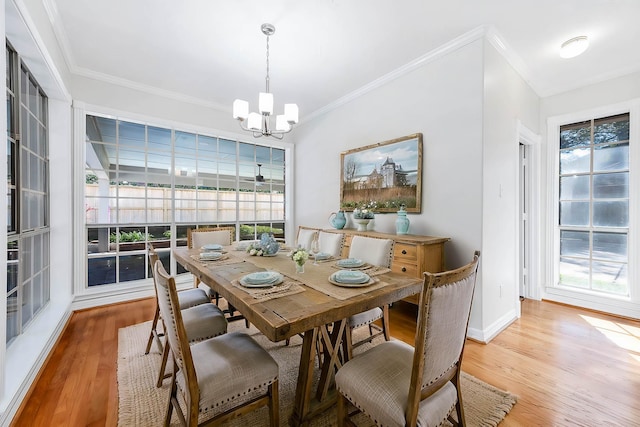 dining area featuring ornamental molding, light hardwood / wood-style floors, and a notable chandelier