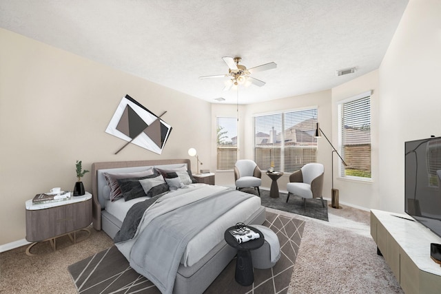 carpeted bedroom with a textured ceiling and ceiling fan