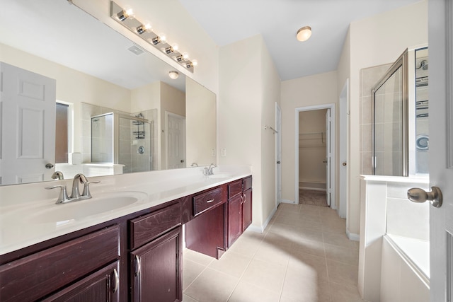 bathroom with an enclosed shower, vanity, and tile patterned floors