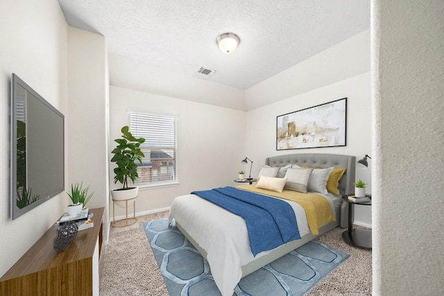 bedroom with light colored carpet and a textured ceiling