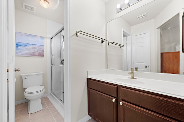 bathroom featuring toilet, an enclosed shower, vanity, and tile patterned floors