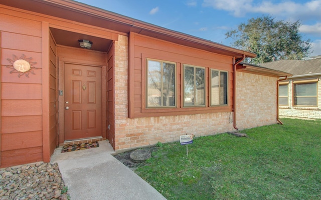 entrance to property featuring a lawn