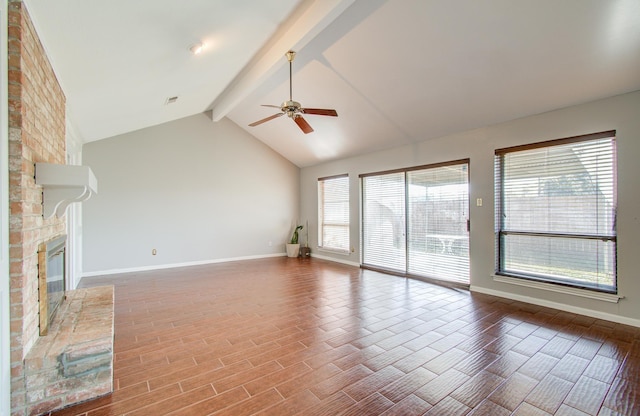 unfurnished living room with beamed ceiling, ceiling fan, a fireplace, and a wealth of natural light