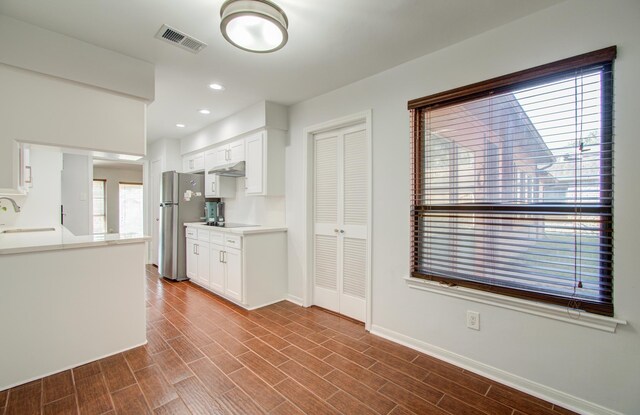 kitchen featuring white cabinetry, sink, dark wood-type flooring, and stainless steel refrigerator