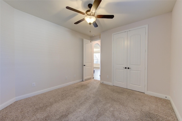 unfurnished bedroom with carpet flooring, ceiling fan, and a closet