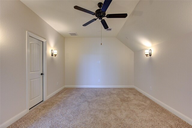 spare room featuring ceiling fan, lofted ceiling, and light carpet