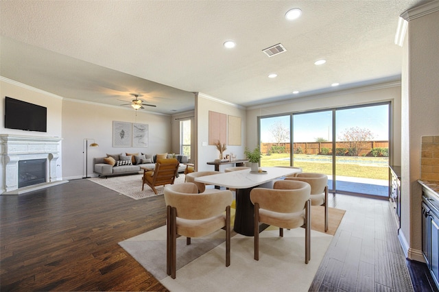 6611 Hollow Bay Ct, Katy, TX 77493 - dining space with crown molding, a fireplace, wood-type flooring, recessed lighting, and a textured ceiling