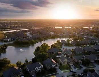 aerial view at dusk with a residential view and a water view