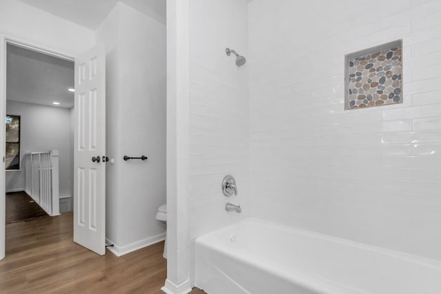 bathroom with wood-type flooring, toilet, and bathtub / shower combination