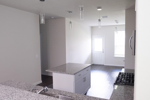 kitchen featuring sink, white cabinetry, pendant lighting, and a center island