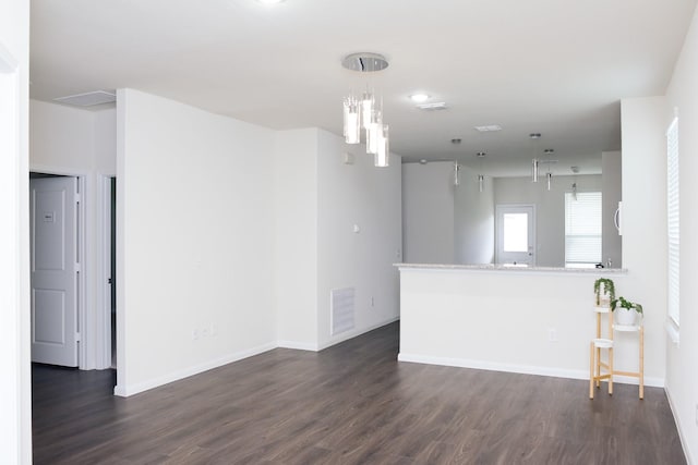 empty room featuring dark hardwood / wood-style flooring and a chandelier