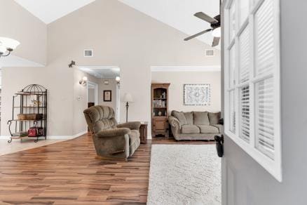 living room with ceiling fan, hardwood / wood-style floors, and high vaulted ceiling