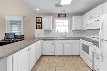 kitchen with sink, white cabinets, white appliances, light tile patterned flooring, and a healthy amount of sunlight