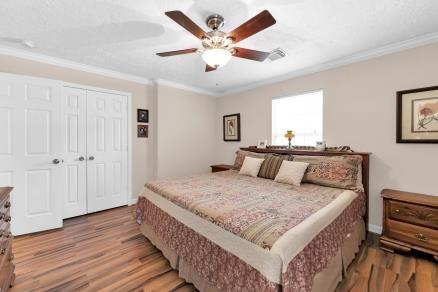 bedroom featuring a closet, ceiling fan, hardwood / wood-style flooring, and ornamental molding