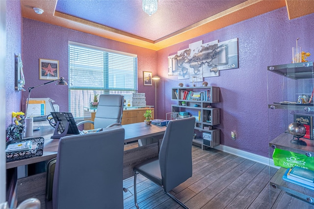 office with a textured ceiling, dark hardwood / wood-style floors, and a raised ceiling