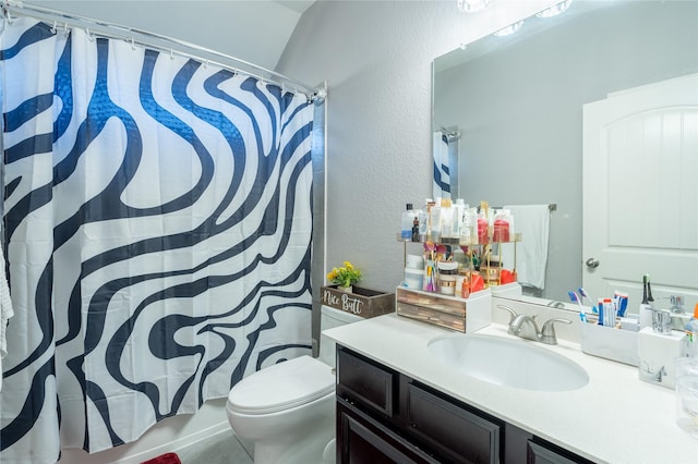 bathroom featuring toilet, vanity, and lofted ceiling