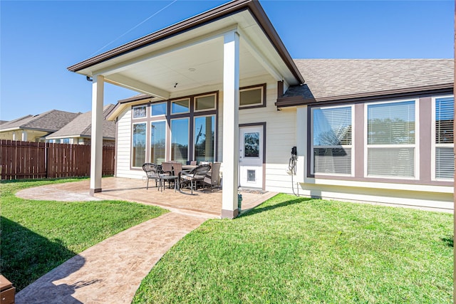 rear view of house with a patio area and a lawn