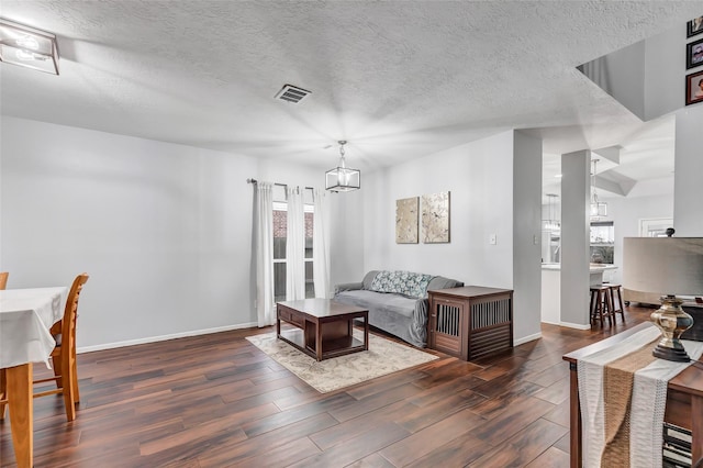 living room with a textured ceiling and a chandelier