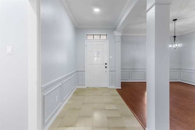 entryway with an inviting chandelier and crown molding