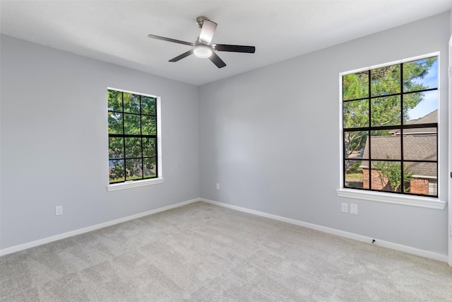 carpeted empty room featuring a healthy amount of sunlight and ceiling fan