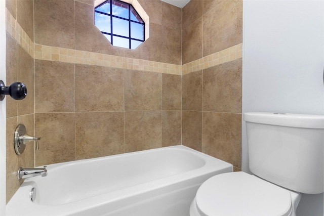 bathroom featuring tiled shower / bath combo and toilet